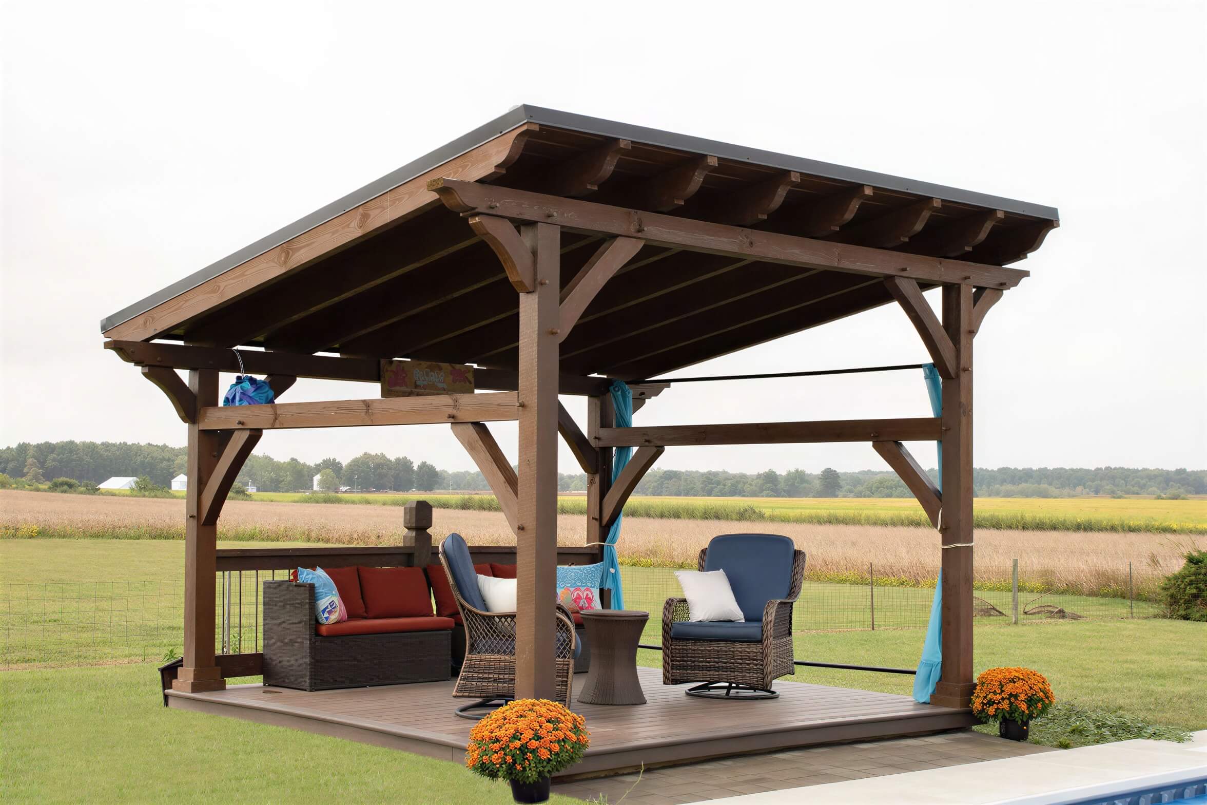 Spacious Brookside Timber Frame Rose Beam Pavilion with outdoor seating on a deck in a rural landscape