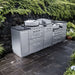 Stainless steel Sunstone TexCajun 9ft Outdoor Kitchen Island Package with grills and storage against a stone wall