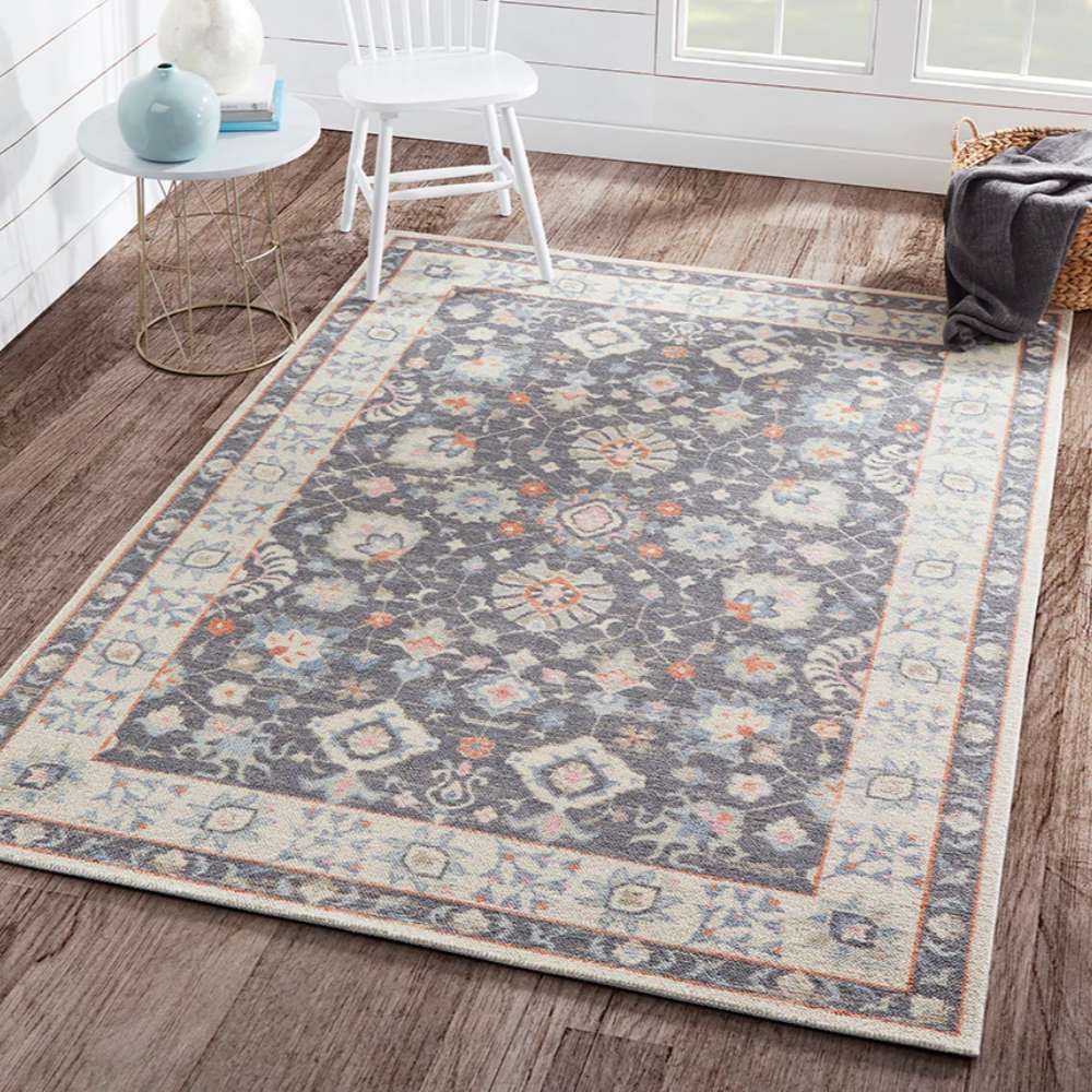Styled in a bright living room, Momeni Anatolia Indoor Rug - ANA-8 Charcoal adds elegance with its bold charcoal center and light border