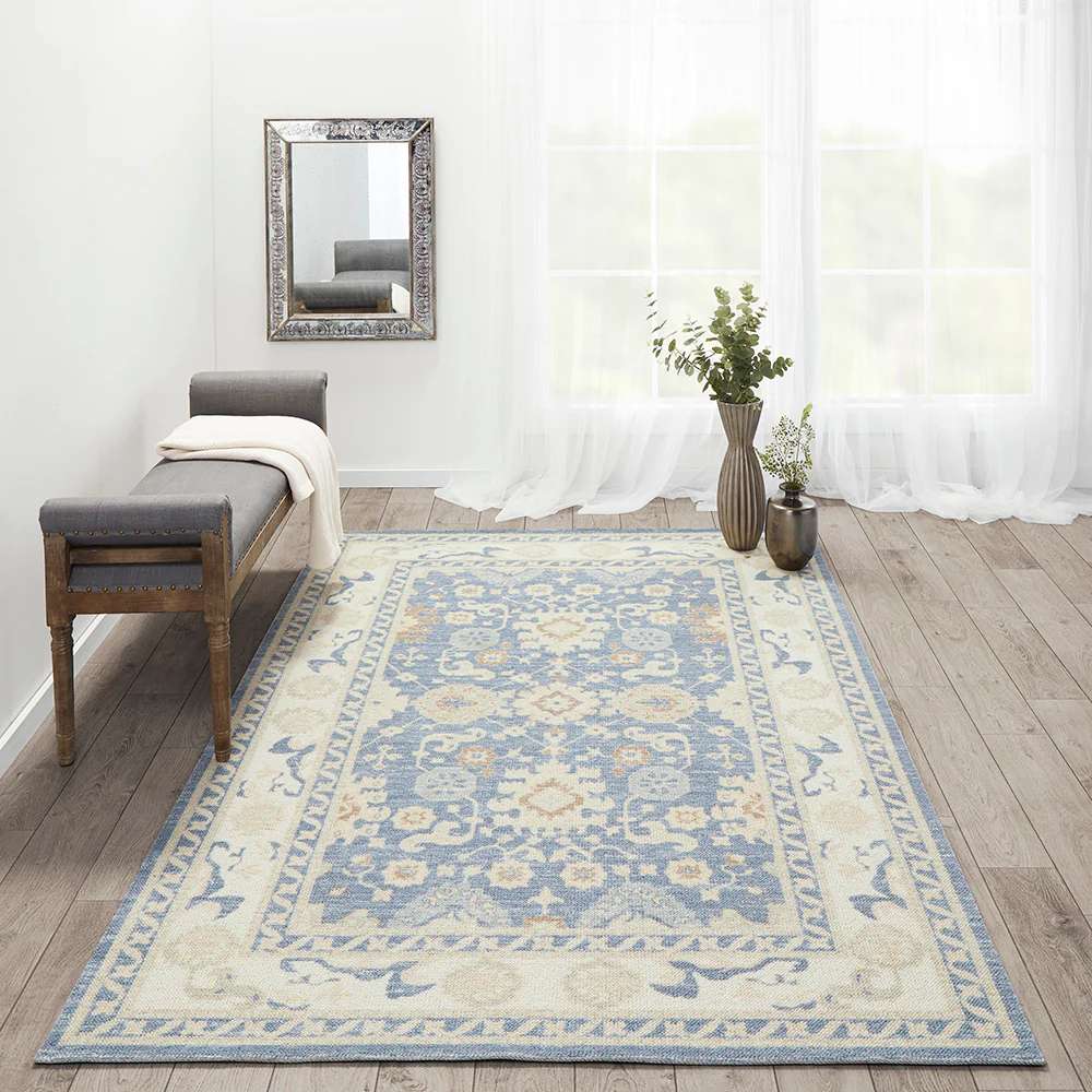 Styled in a bright room with a bench and vases, the Momeni Anatolia Indoor Rug - ANA-7 Light Blue brings a soft, classic touch