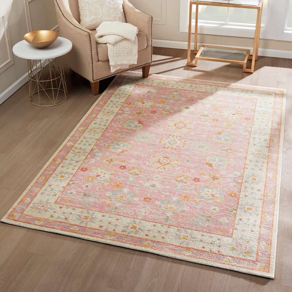 Styled in a living room, Momeni Anatolia Indoor Rug - ANA-8 Pink adds warmth and color with its vintage design and soft pastel hues