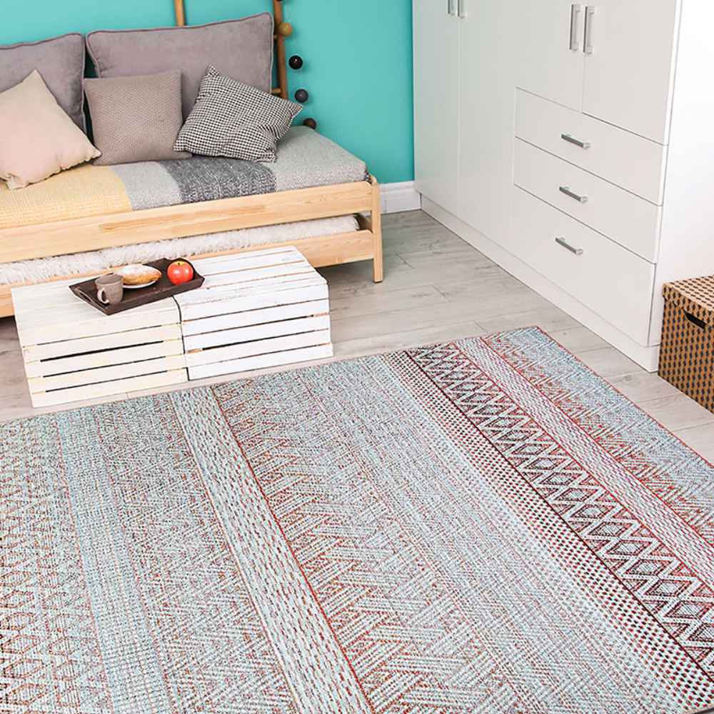 Styled in a cozy room, the Couristan Cape Indoor/Outdoor Rug - Gables/Hibiscus complements wooden furniture and bright turquoise walls with its colorful woven design