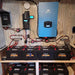 Sun Gold Power 12000W 48V Split Phase Pure Sine Wave Inverter Charger installed on a wall above a large battery bank in an off-grid power system