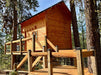 Sunlight shines on the Sawmill Structures The Jumbo Grand Loft 130 SD Garden Room nestled among pine trees