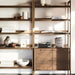 Sunlit display of Crate & Barrel Tate 36" Walnut Wood 3-Shelf Storage Bookcase Cabinet styled with books, ceramics, and décor on open shelves above closed cabinet storag