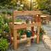 Sunny backyard shows a wooden gardening table with plants and tools, with Outdoor Living Today 4×2 Western Red Cedar Potting Bench at the center