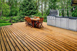 Sunstone Bayou 8ft 6in Outdoor Kitchen Island Package on a wooden deck with grill, cabinets, and outdoor dining setup