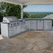 Sunstone Savanna 16ft Outdoor Cabinet Package with 60° Angle is a stainless steel outdoor kitchen with grill and sink on a covered patio overlooking a forest