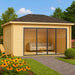 Surrounded by a garden with flowers and shrubs, the GardenHouse24 USA Pavilion ALU 44D Garden Room is shown as a tranquil lounge space