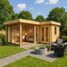 Surrounded by greenery, the GardenHouse24 USA ALU Concept Quinta 70 Garden Room features floor-to-ceiling windows and a stylish interior with a desk and sofa
