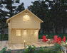 Surrounded by tall pines, the Sawmill Structures The Jumbo Grand Loft 130 SD Garden Room glows softly in the evening with warm lights and a front deck