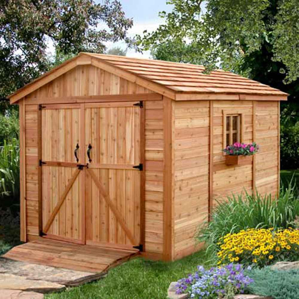 Surrounded by lush flowers, the Outdoor Living Today 8×12 Space Master Storage Shed has a shingled roof and flower box under a side window