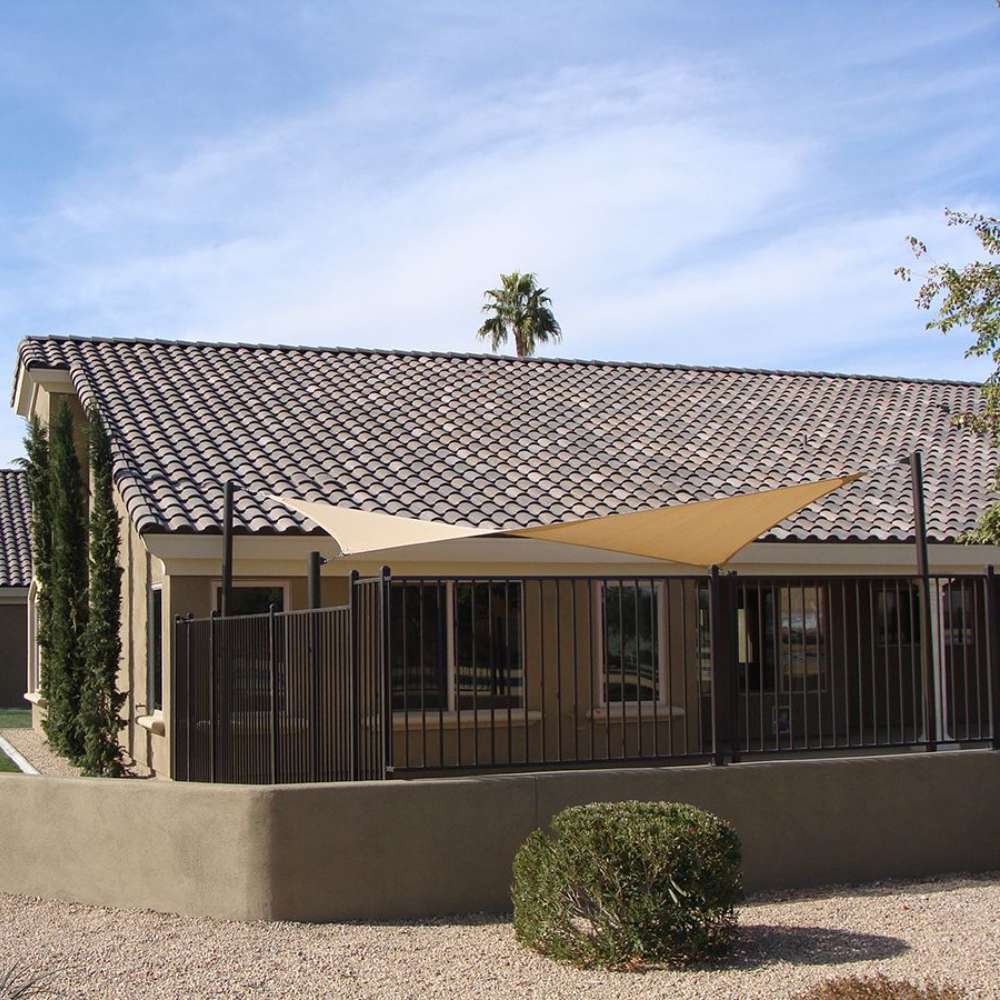 Tenshon Rectangle Shade Sail above a fenced residential patio, adding shade beside a stucco home