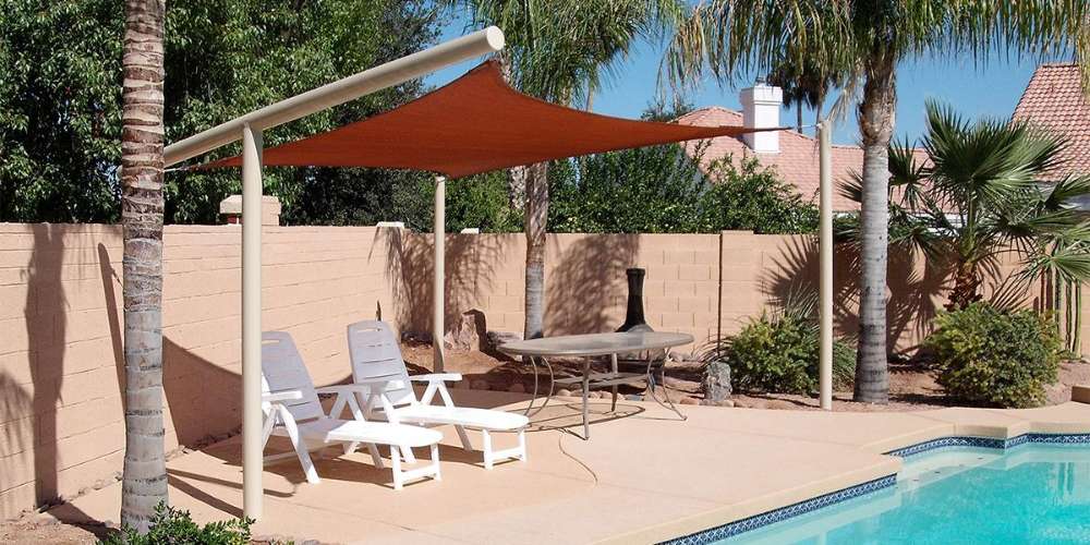 Tenshon Rectangle Shade Sail over a backyard pool patio with lounge chairs and outdoor seating