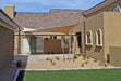 Tenshon Square Shade Sail shades a backyard courtyard between stucco walls, providing sun protection over a patio and gravel landscape