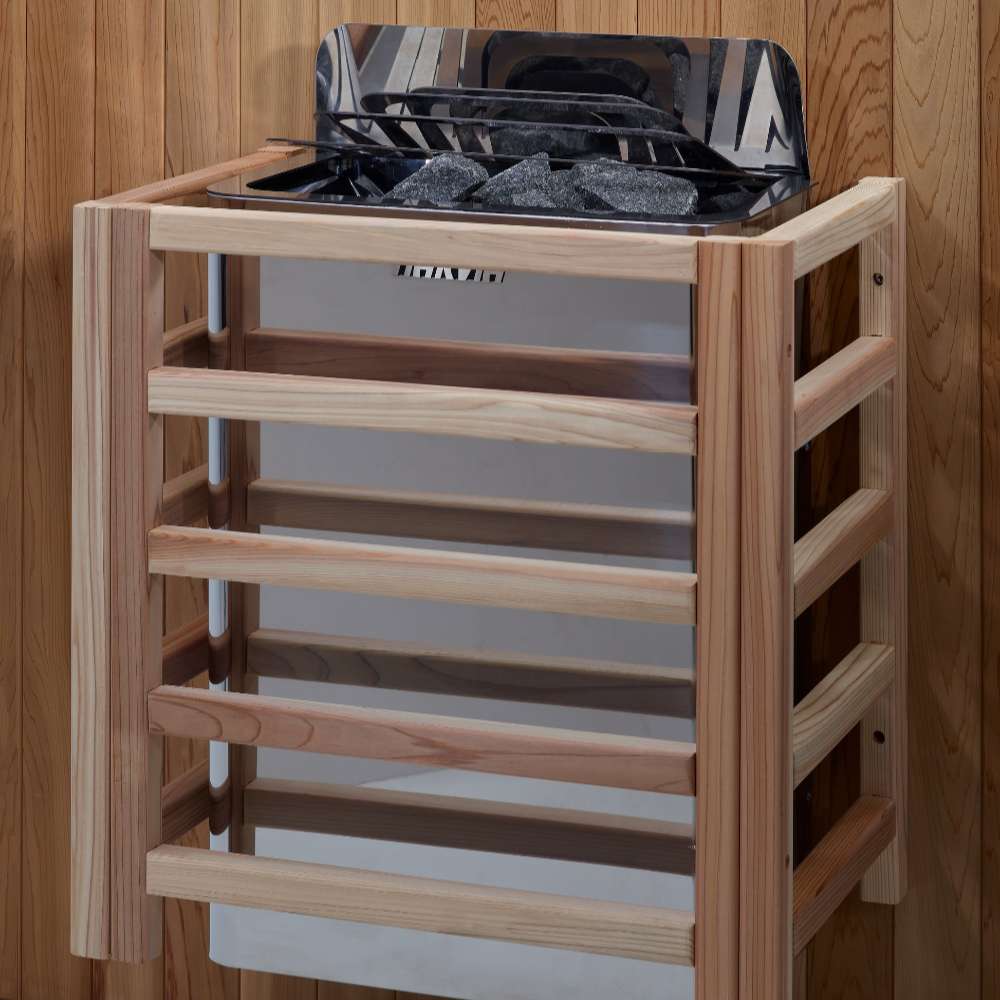 The Harvia stove for Golden Designs Soria 3 Person Indoor Hybrid Sauna with Full Spectrum IR and Harvia Stove mounted on a cedar wall inside a slatted light wood safety guard