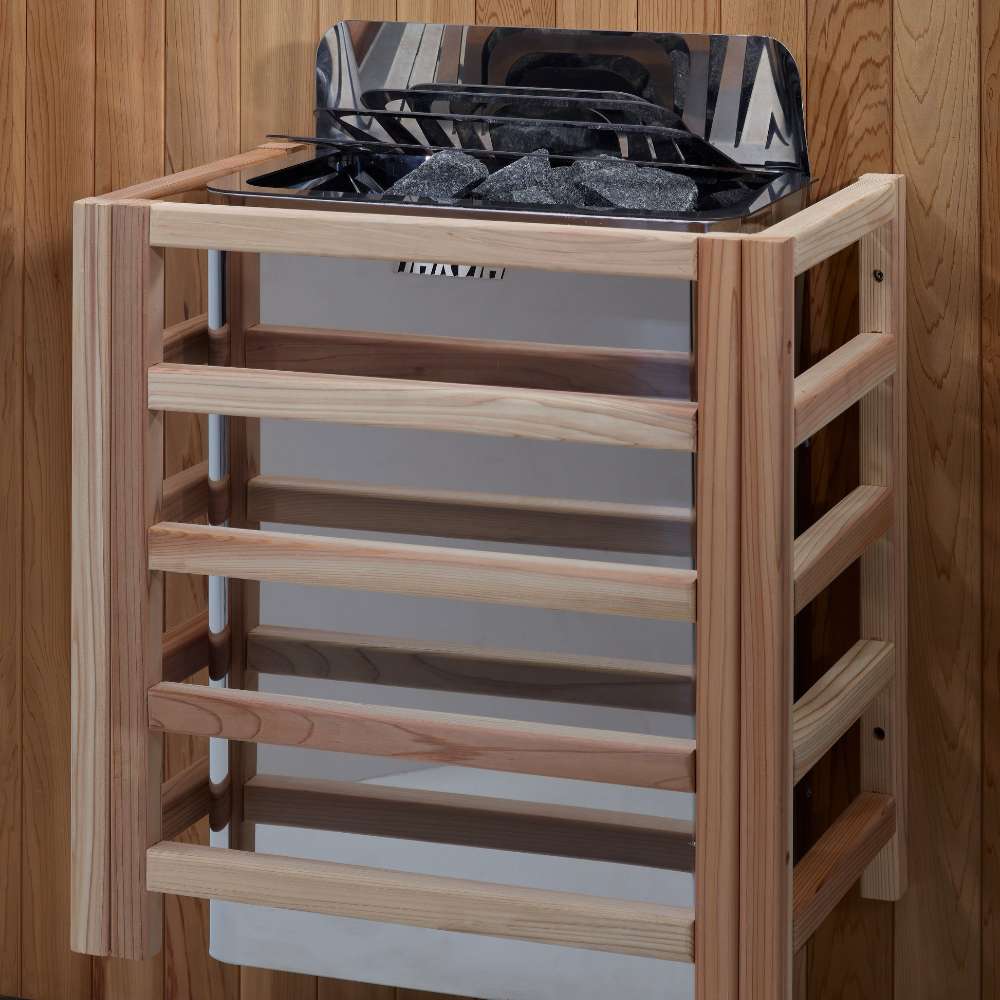 The Harvia stove for Golden Designs Toledo 6 Person Indoor Hybrid Sauna with Full Spectrum IR and Harvia Stove mounted on a cedar wall inside a slatted light wood safety guard