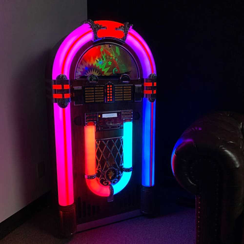 The Arkrocket Saturn V Full Size Bluetooth Vinyl Record Jukebox glows brightly in a dark room