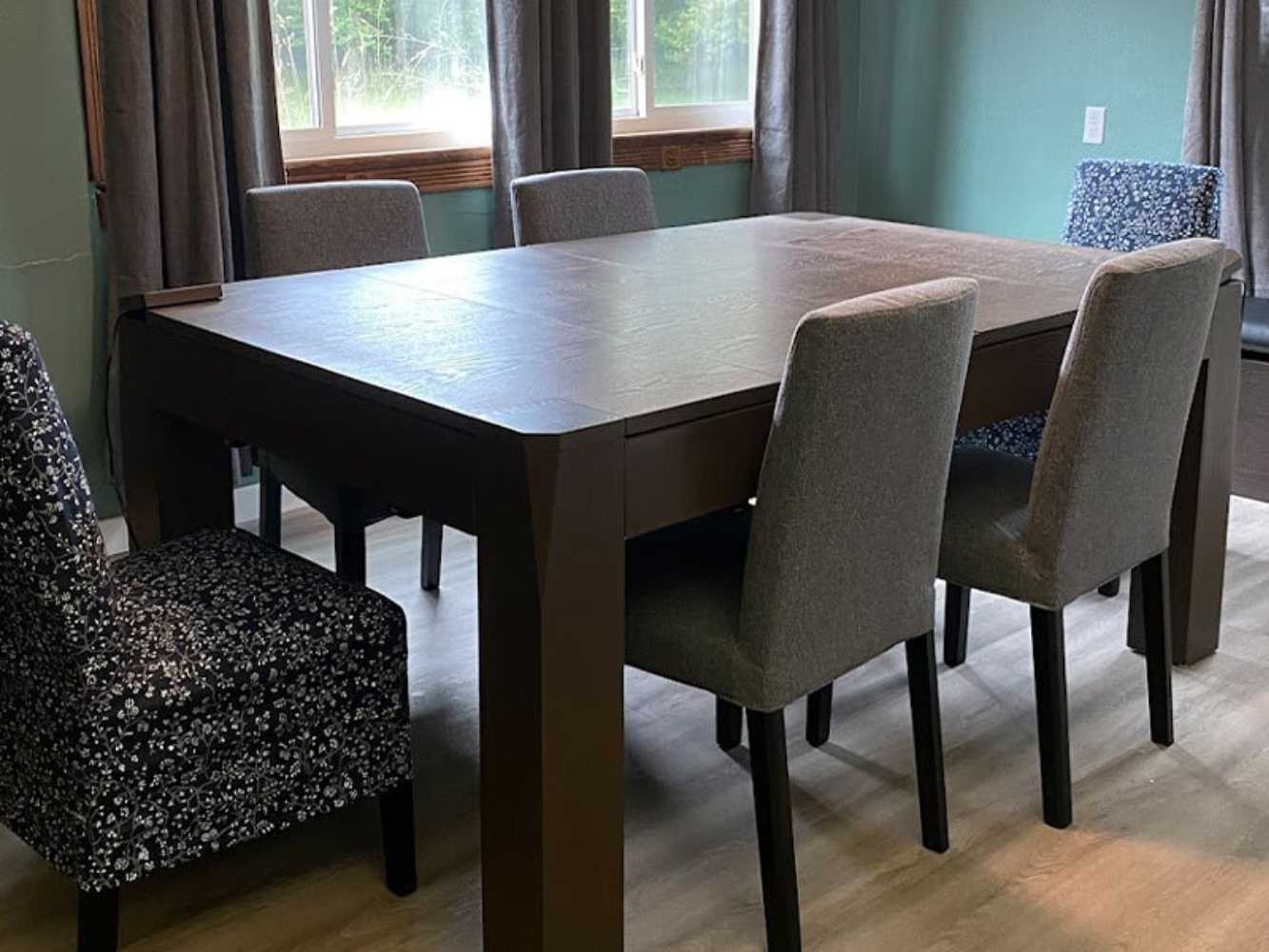 The Game Theory Tables Origins Lit Game Table in this room serves as a sleek, multipurpose dining table with gray chairs