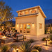 The Versa 160 Atrium Freedom Loft Studio illuminated during a bright Nevada night as friends watch a sports game inside, framed by desert landscaping, pathway lights, and distant mountains.

