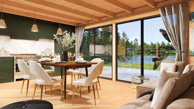 The interior of the GardenHouse24 USA Ramsay 70 A ALU Garden Room is warmly lit and elegantly furnished with a dining table, kitchen, and soft curtains framing scenic lake views