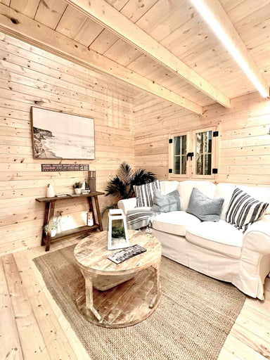 The living area in the Sawmill Structures Ontario Grand Loft 107 SD Garden Room features a white couch, wood coffee table, and a soft jute rug