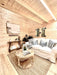 The living area in the Sawmill Structures Ontario Grand Loft 107 SD Garden Room features a white couch, wood coffee table, and a soft jute rug