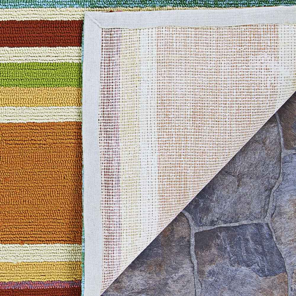 The backing of the Couristan Covington Indoor/Outdoor Rug - Sherbet Stripe/Multi is lifted to reveal its anti-slip mesh and neatly bound edge