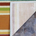 The backing of the Couristan Covington Indoor/Outdoor Rug - Sherbet Stripe/Multi is lifted to reveal its anti-slip mesh and neatly bound edge