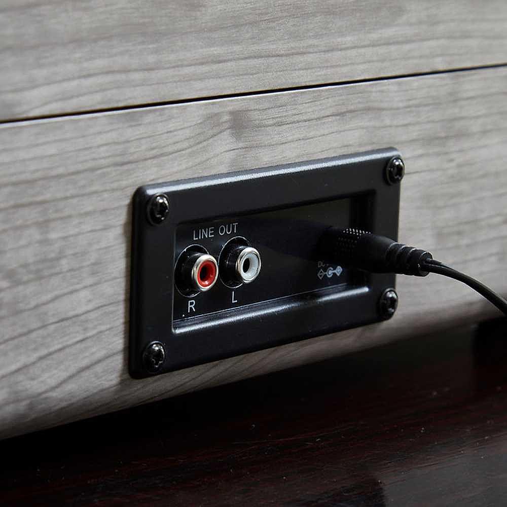 The back of Arkrocket Curiosity Suitcase Bluetooth Turntable (Gray Wood Grain) highlights its line-out ports with cables plugged in