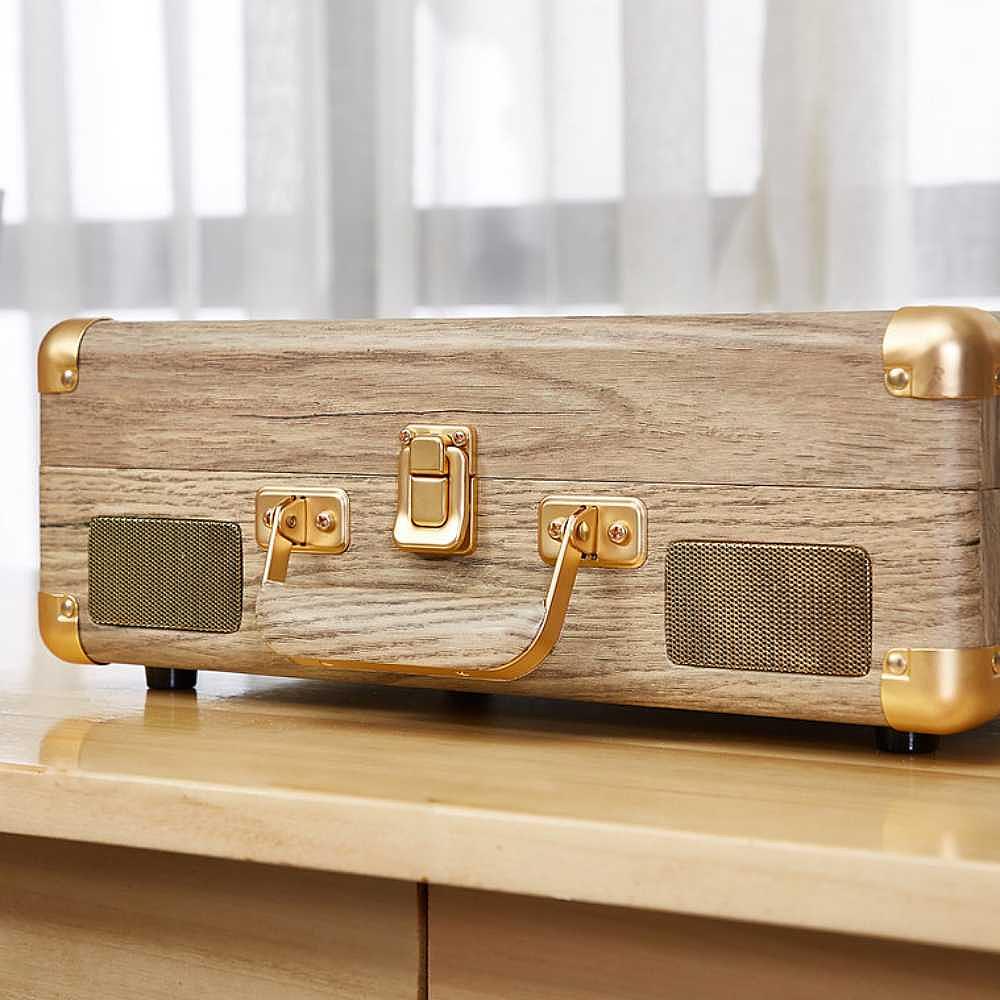 The back of Arkrocket Curiosity Suitcase Bluetooth Turntable (Wood Grain) is closed revealing its wood grain finish and built-in speakers