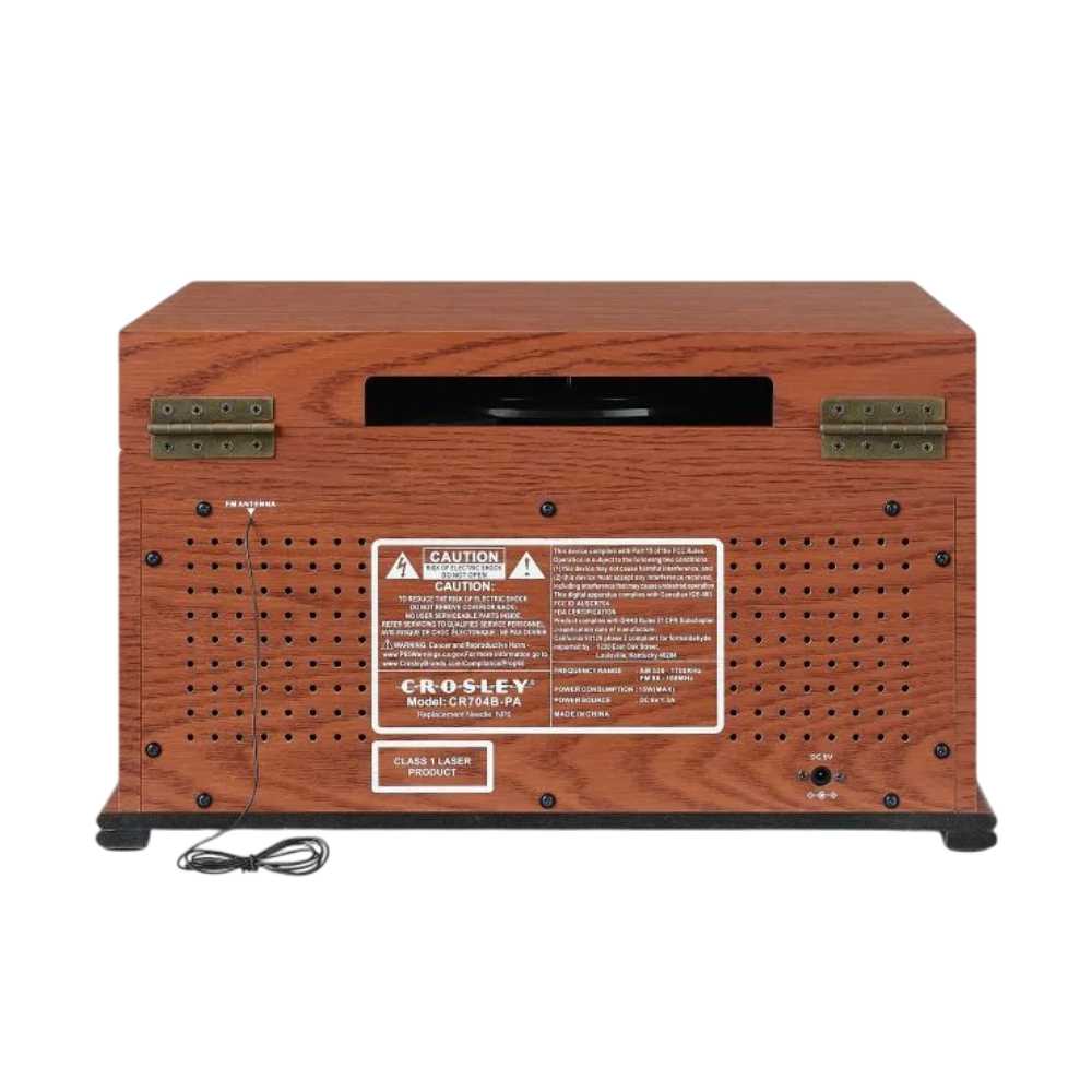 The back panel of the Crosley Musician Entertainment Center - Paprika reveals ventilation holes, the manufacturer label, and a wired antenna for radio reception