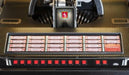 The button panel of the Crosley Vinyl Rocket Full-Size Jukebox - Oak includes numbered controls and nostalgic red selection buttons