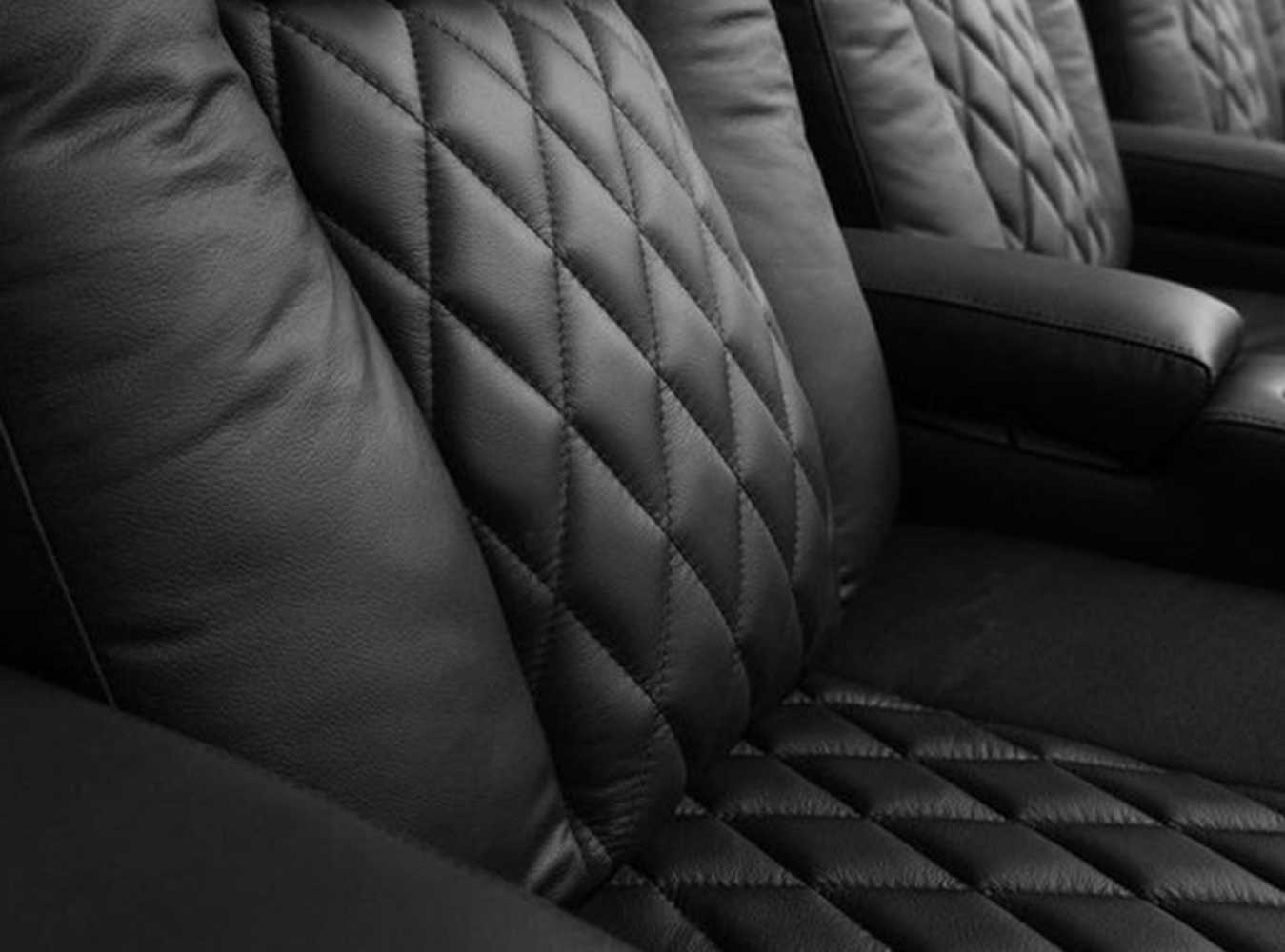 The close-up image shows the luxurious diamond-stitched leather of the Valencia Tuscany Single Home Theater Seating