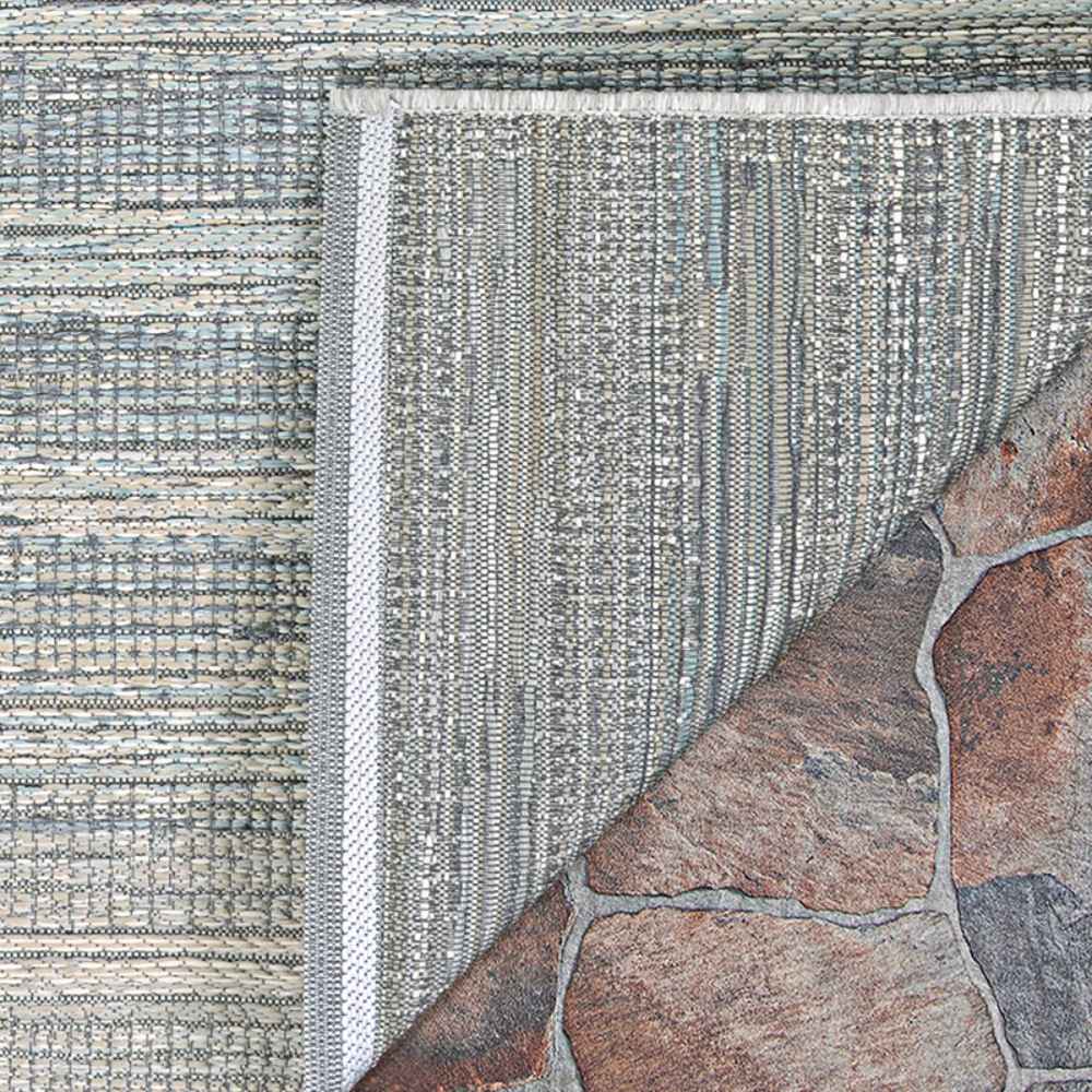 The corner of the Couristan Cape Indoor/Outdoor Rug - Shallows/Taupe-Grey is flipped to display the durable backing and fine construction