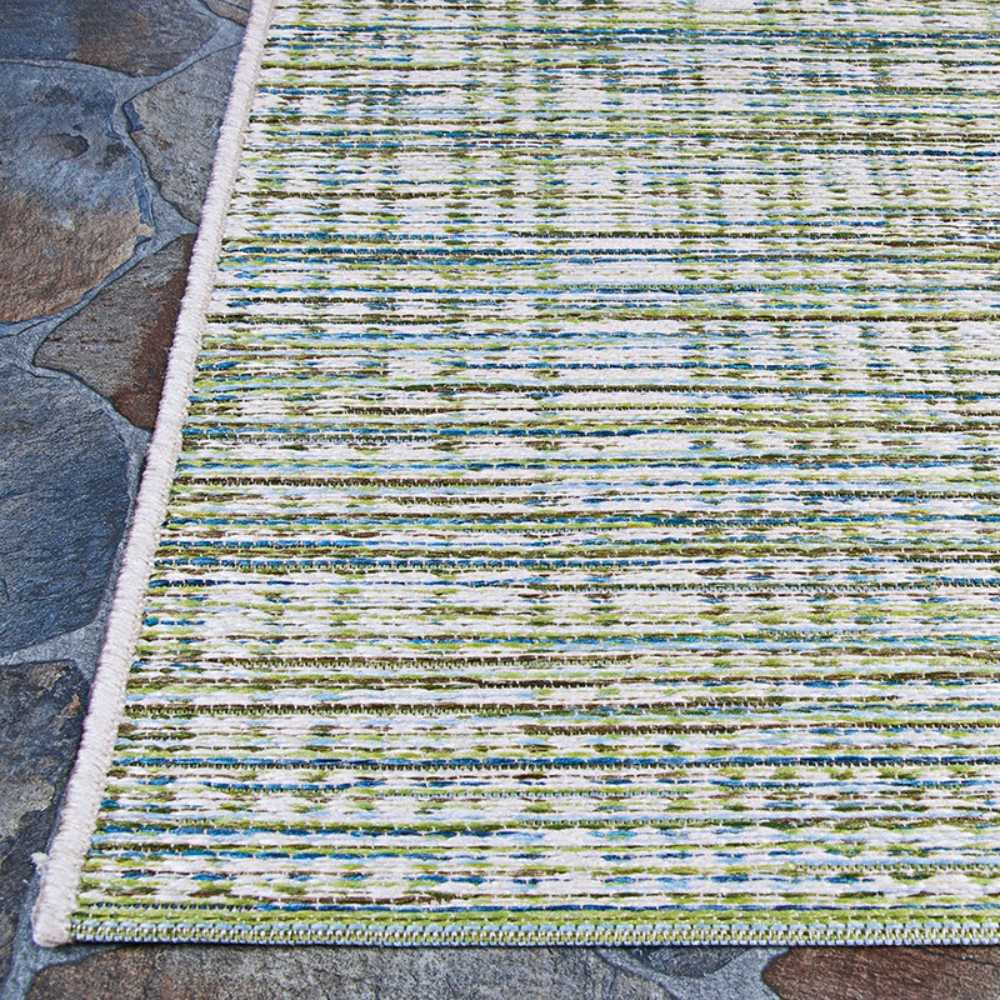 The edge of the Couristan Cape Indoor/Outdoor Rug - Falmouth/Ivory-Hunter is displayed on stone flooring, revealing clean stitching and its striped design
