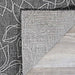 The flipped corner of the Couristan Charm Indoor/Outdoor Rug - Botanical/Ash displays the backside and its clean, well-structured weave