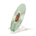 The folding stand from the Crosley 5-in-1 Record Cleaning Kit holds a translucent green vinyl record