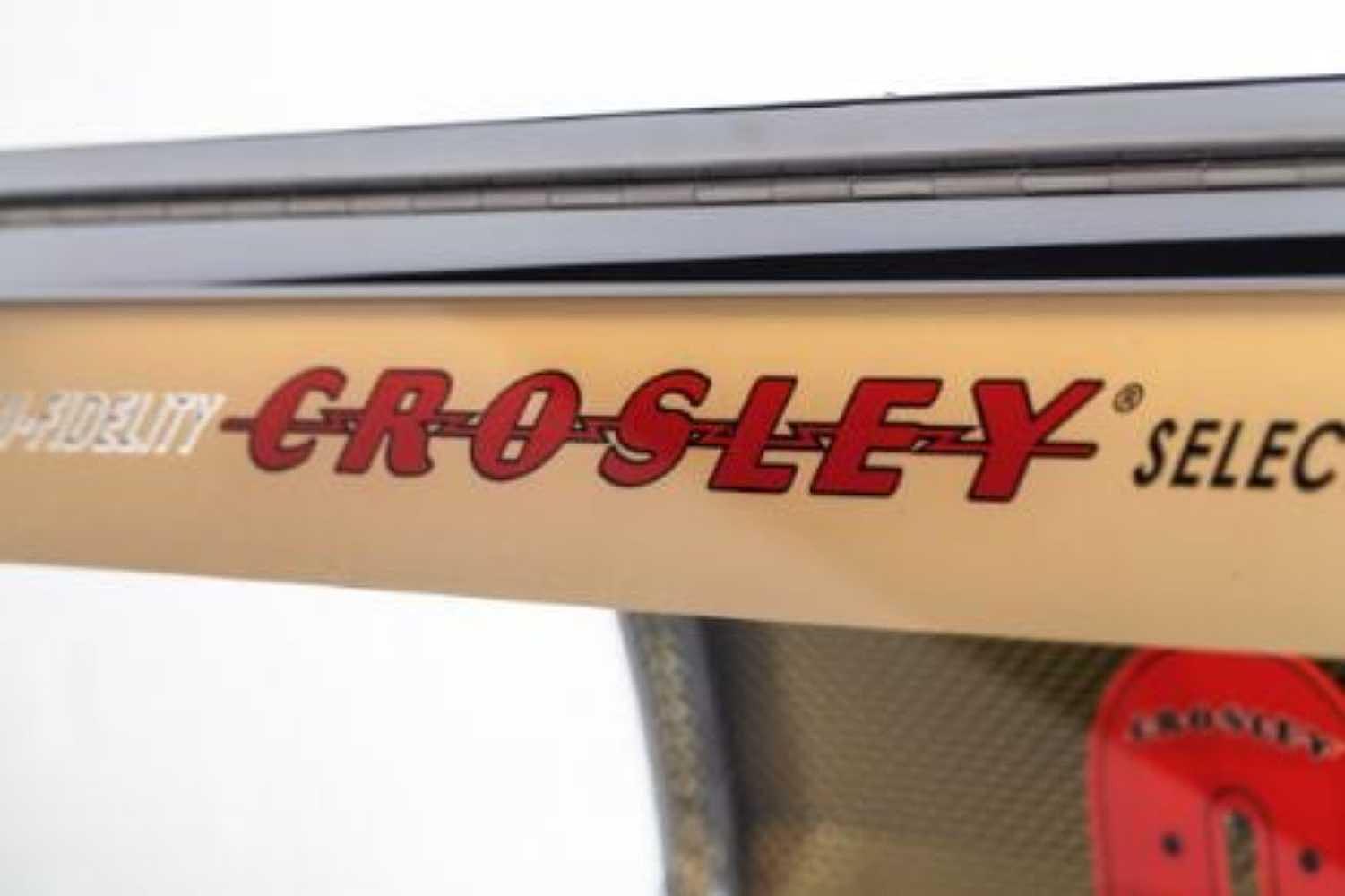 The illuminated top panel of the Crosley Rocket 80 CD Bluetooth Full-Size Jukebox - Oak highlights its nostalgic lettering and seamless retro curves