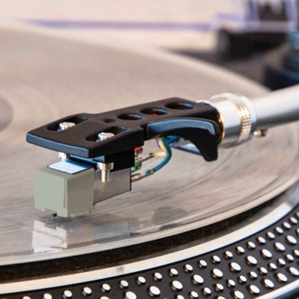 The image demonstrates the Crosley NP5 Replacement Needle installed on a turntable arm, ready to play a vinyl record