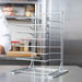 The image features the Chicago Brick Oven 7 Slot Wall Mounted Pizza Pan Rack empty on a kitchen counter