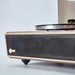 The image focuses on the front speaker grille of Arkrocket Huygens Bluetooth Turntable with Built-in Speakers (Walnut)