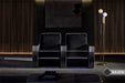 The image portrays two Valencia Naples Elegance Home Theater Seating chairs in a sophisticated home theater setting with ambient lighting