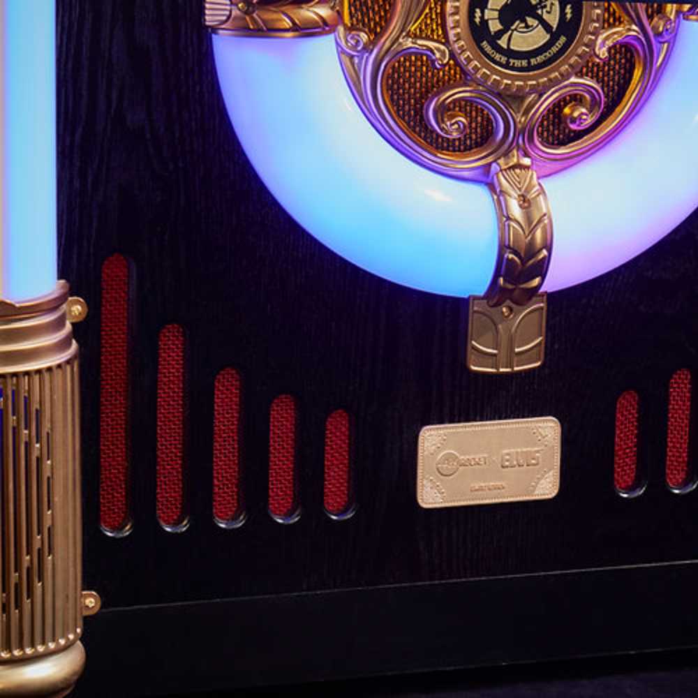 The image shows a close-up of the glowing neon lights and intricate golden details on Arkrocket x Elvis Presley Saturn V Full Size Bluetooth Vinyl Record Jukebox