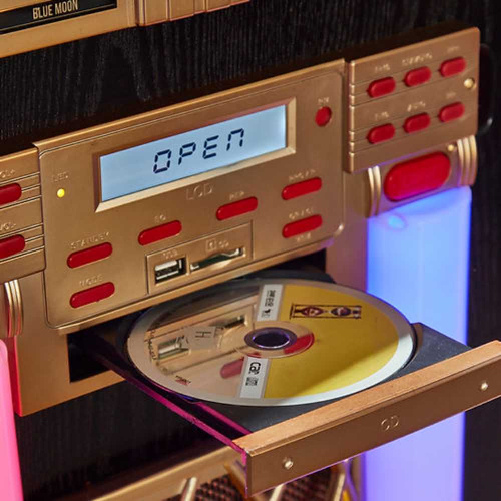 The image shows the CD player of Arkrocket x Elvis Presley Saturn V Full Size Jukebox with Stand with a disc being inserted into the golden retro-style interface