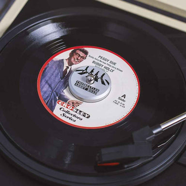 The image shows the Crosley The BEATLES 45 Adapter - Abbey Road attached to a vinyl record playing on a turntable with a Buddy Holly label