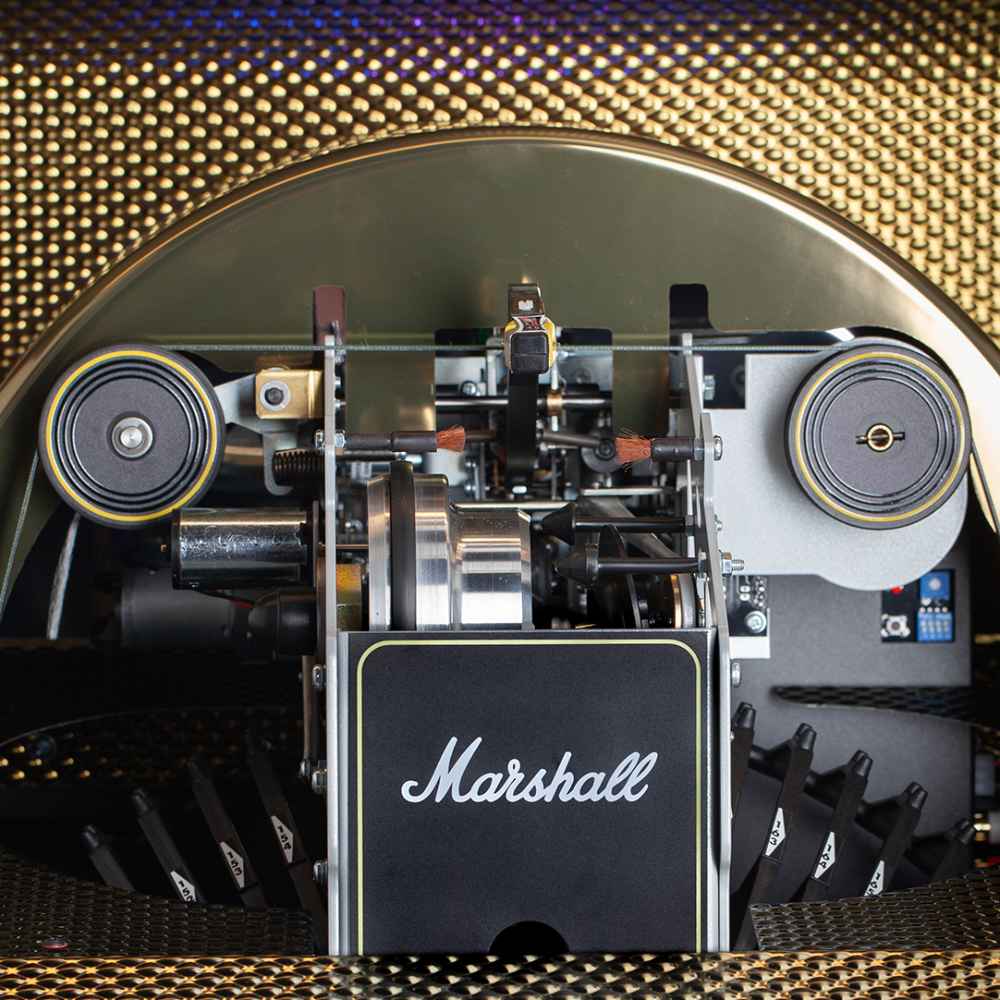 The internal mechanism of the Marshall Rocket Vinyl Jukebox - Black reveals detailed components, including rollers and brushes for vinyl operation