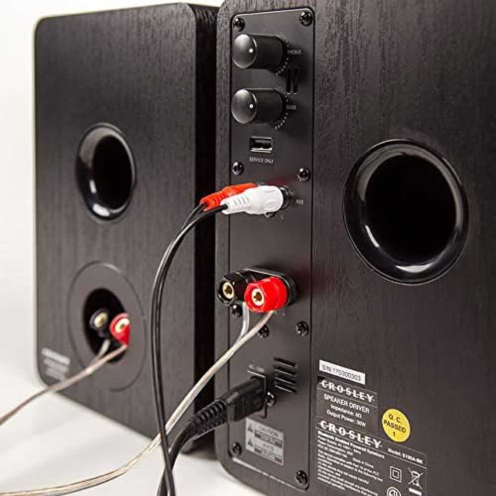 The rear view of the Crosley KT6101 K-Series Turntable System - Mahogany speakers shows the treble and bass controls, RCA cable ports, and bass reflex ports