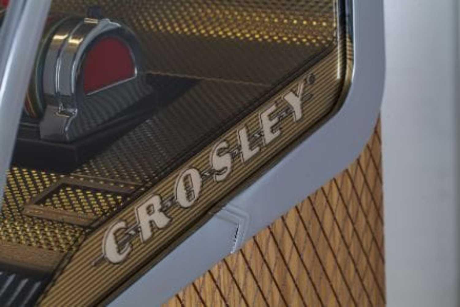 The side profile of the Crosley Rocket 80 CD Bluetooth Full-Size Jukebox - Oak showcases its iconic logo and textured oak paneling