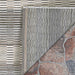 The underside of the Couristan Cape Indoor/Outdoor Rug - Torrent/Sky Blue-Grey is shown flipped up, revealing its backing and quality stitching